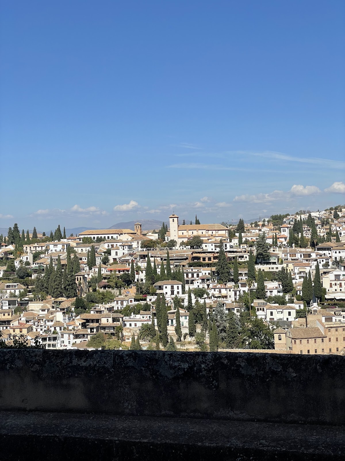 Narrow whitewashed street in Granada's Albaicín district — a highlight of any Granada travel guide