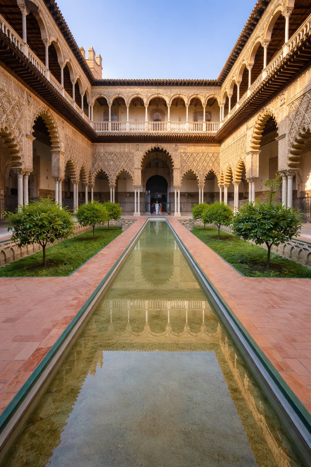 Courtyard of the Maidens in the Royal Alcázar of Seville, reflecting pool and Mudéjar arches — essential Seville travel guide stop