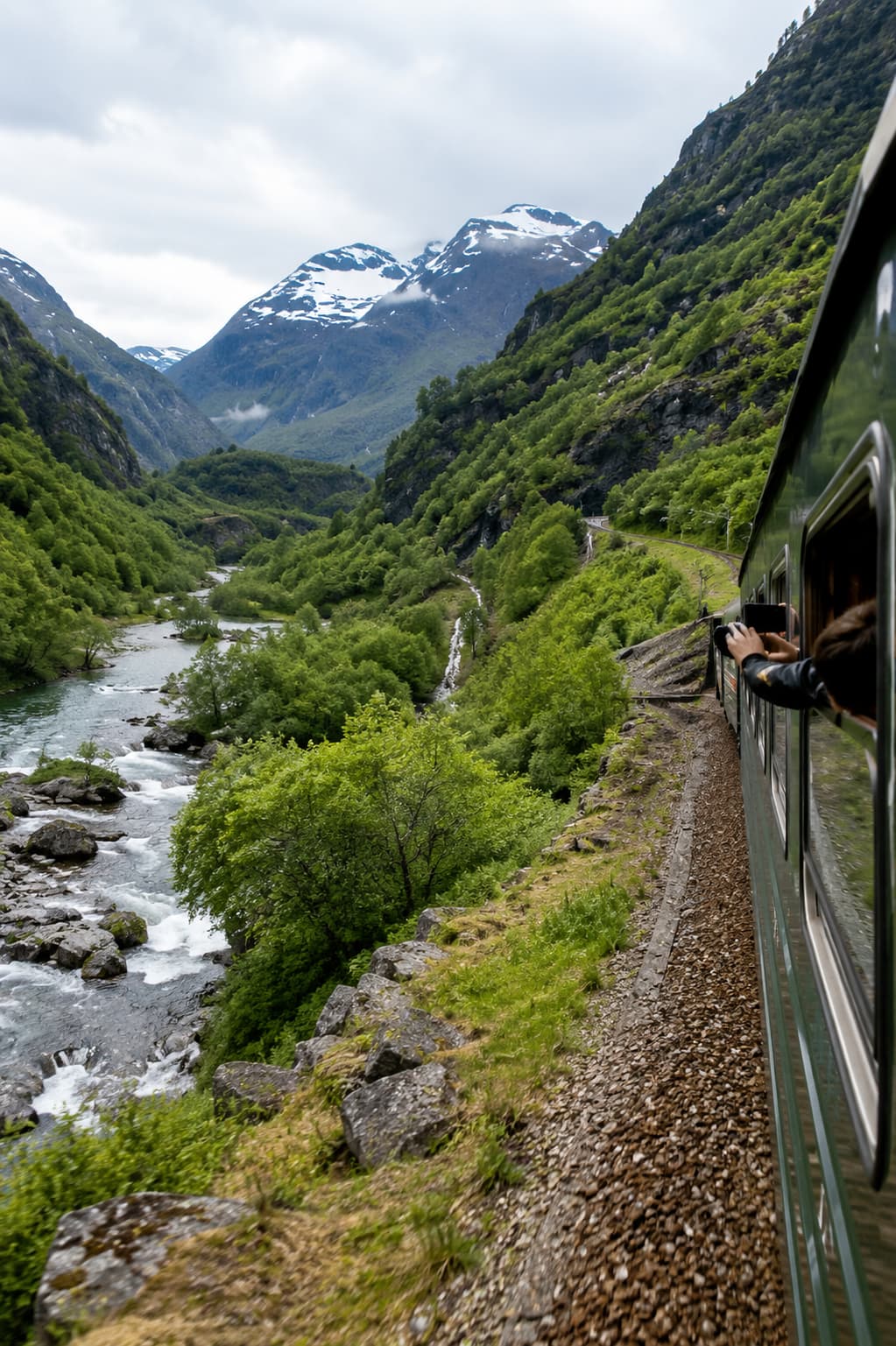 scenic train journey through green mountain valley with river below — slow solo travel