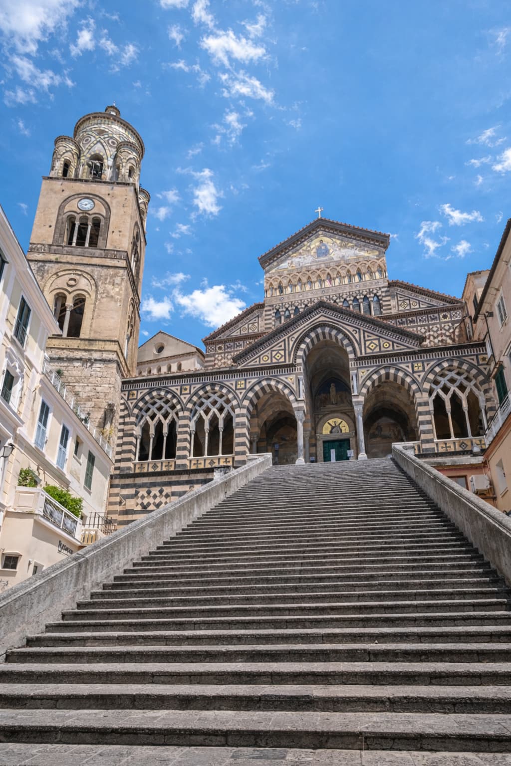 Wide stone steps leading up to the Cathedral of Sant'Andrea in Amalfi town against a blue sky