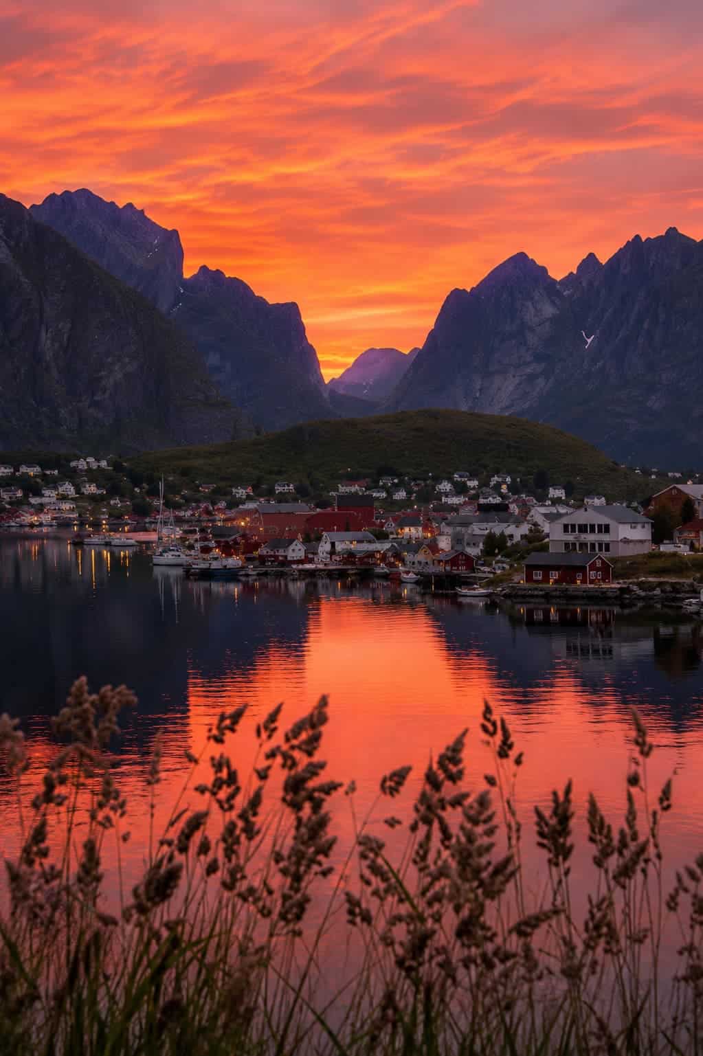 Midnight sun over the Lofoten Islands Norway — golden low light across mountain peaks and still fjord water at 1am in June