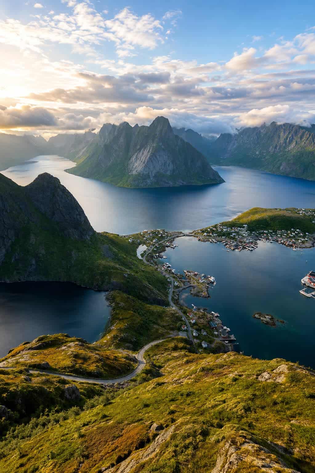 Reinebringen hike Lofoten Islands Norway — hikers on the ridgeline above Reine with fjords and peaks visible in every direction
