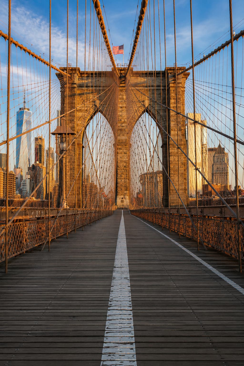 Manhattan Bridge framed between brick warehouse buildings on a clear morning in DUMBO, Brooklyn