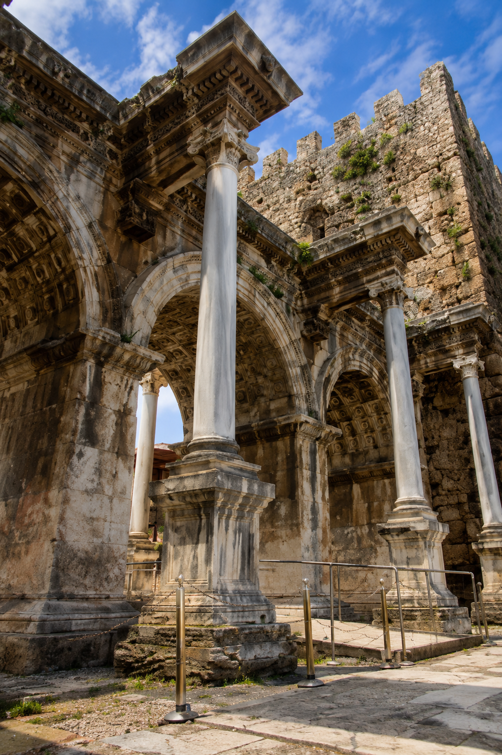 Close-up view of Hadrian's Gate columns and the old city walls in Kaleiçi, Antalya