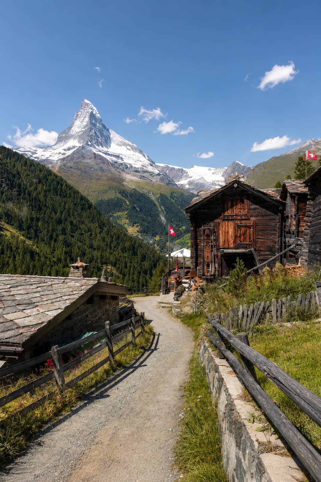 Wooden chalets on a gravel path with the snow-capped Matterhorn rising above Zermatt, Switzerland