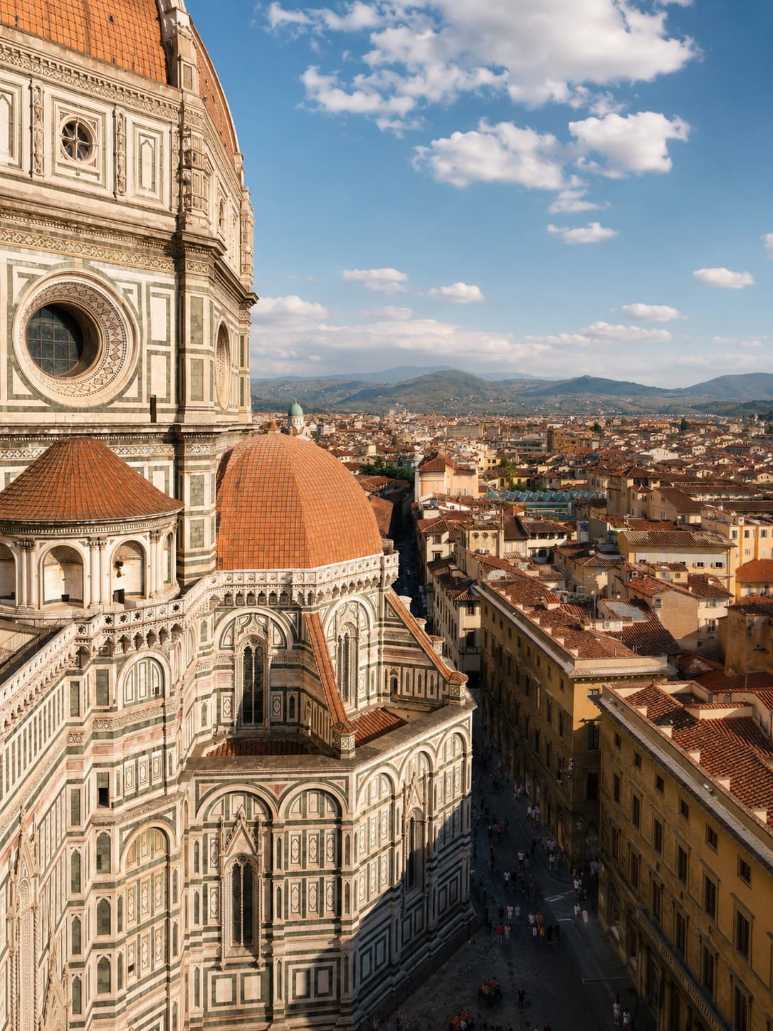The flank of Brunelleschi's dome seen up close from above, with Florence's terracotta rooftops and the Tuscan hills stretching beyond