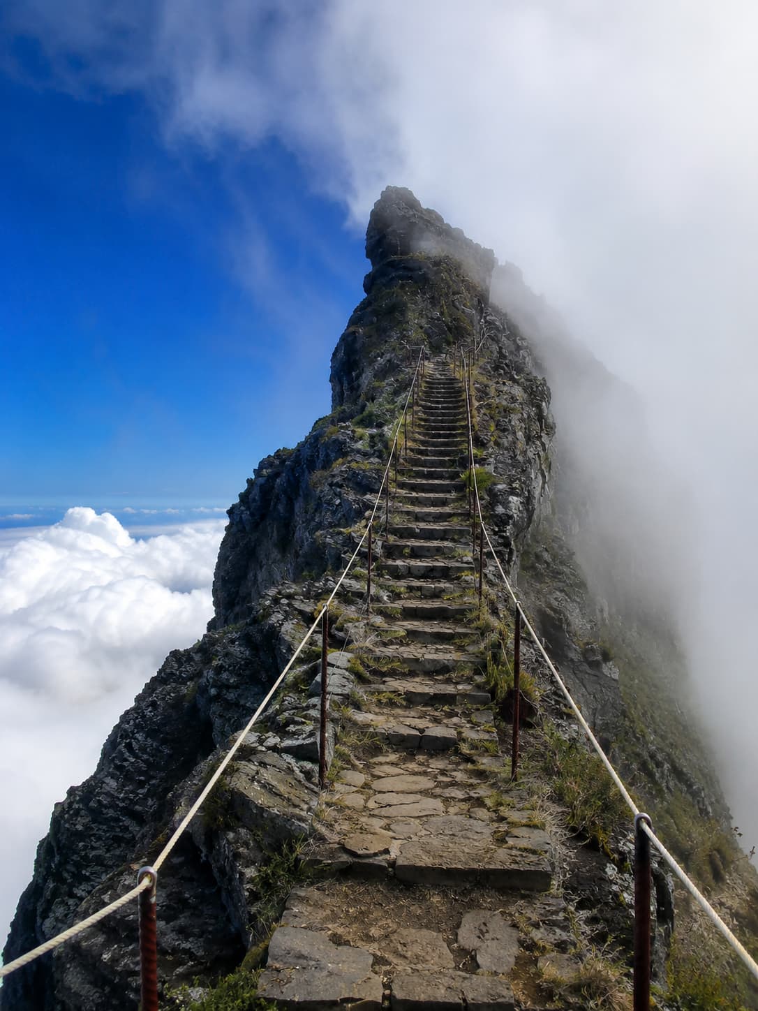 A stone hiking staircase on a ridge above the clouds at Pico do Arieiro, Madeira