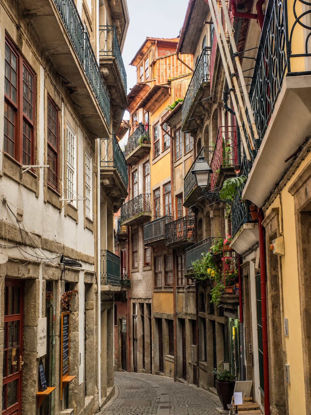 Narrow cobbled lane in Porto's old town with tiled balconied houses on day one of a 3 days in Porto itinerary