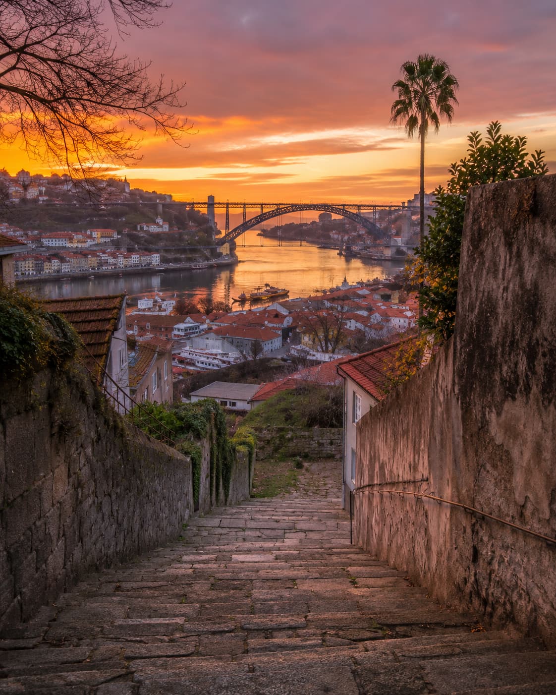 Sunset over the Douro and Dom Luís I bridge seen from a Porto stairway, the best golden-hour view on a 3 days in Porto itinerary