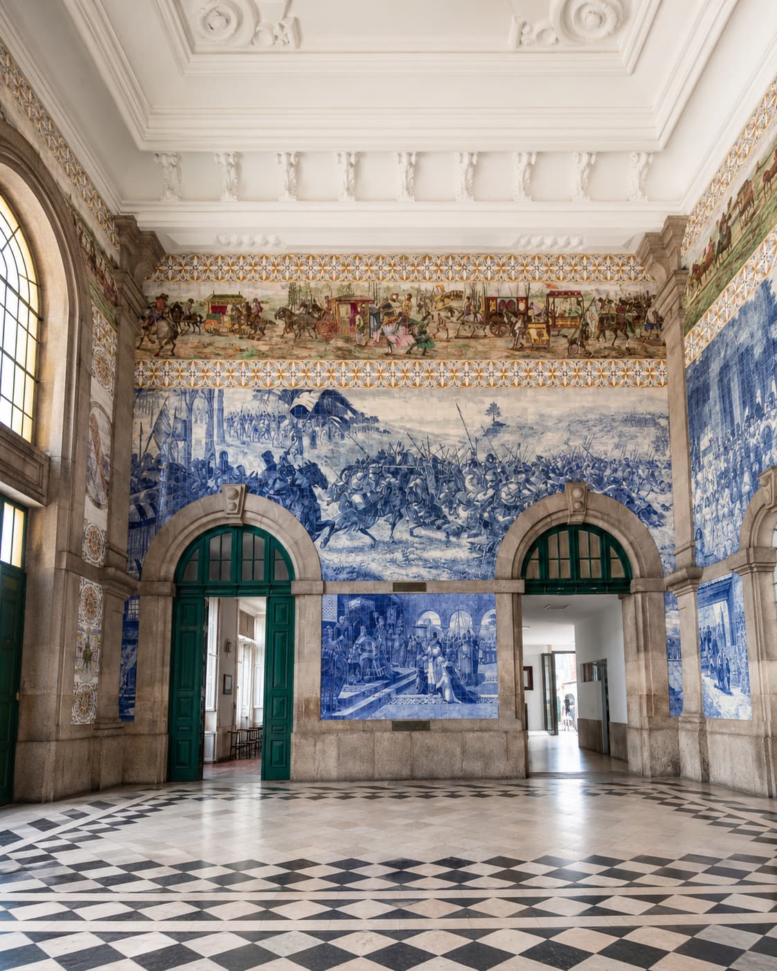 Blue azulejo tile murals and chequered floor inside São Bento railway station in Porto