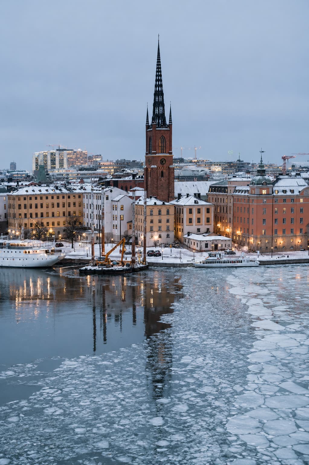 Winter ice floes on the water with snow-covered Riddarholmen rooftops