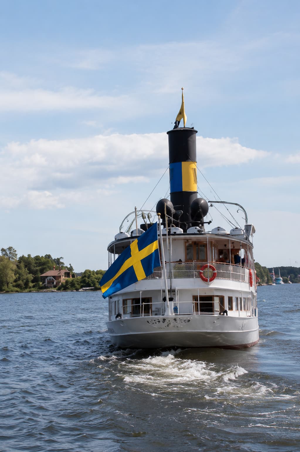 Stockholm archipelago ferry approaching with Swedish flag flying