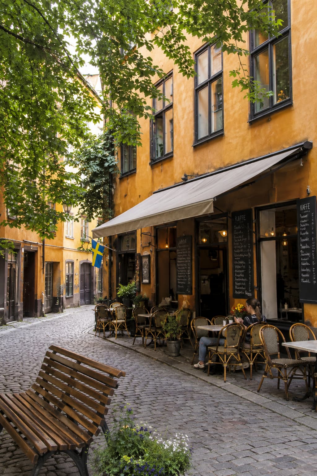 Cobblestone alley in Gamla Stan with yellow facades and outdoor café — 3 days in Stockholm