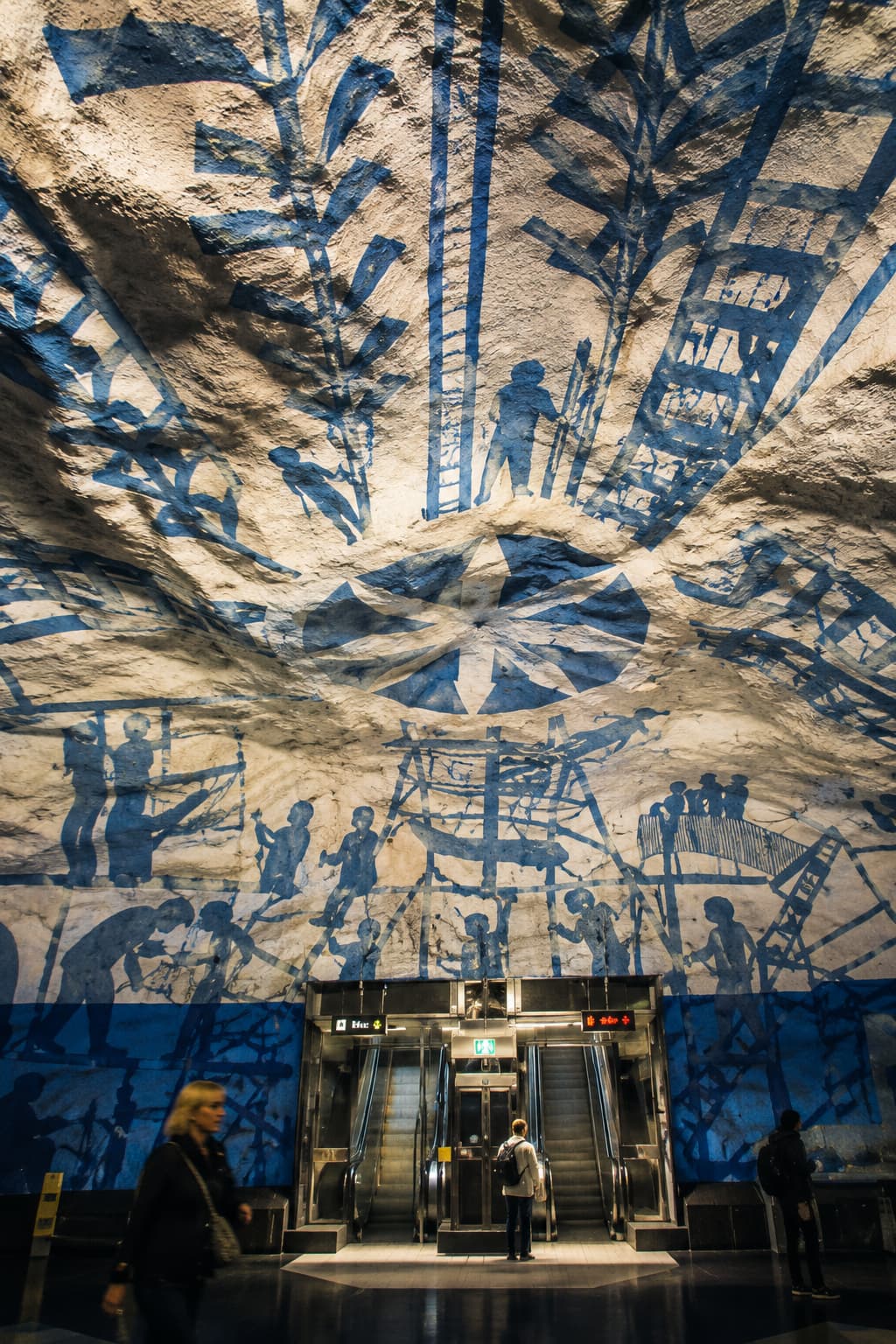 Rådhuset metro station — blue murals across rock-hewn tunnel walls