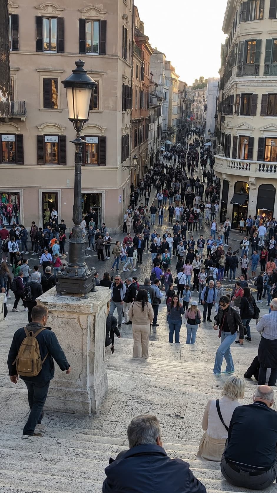 Crowds packing the Spanish Steps and a narrow shopping street in Rome at peak season, the honest picture of August in the wrong place