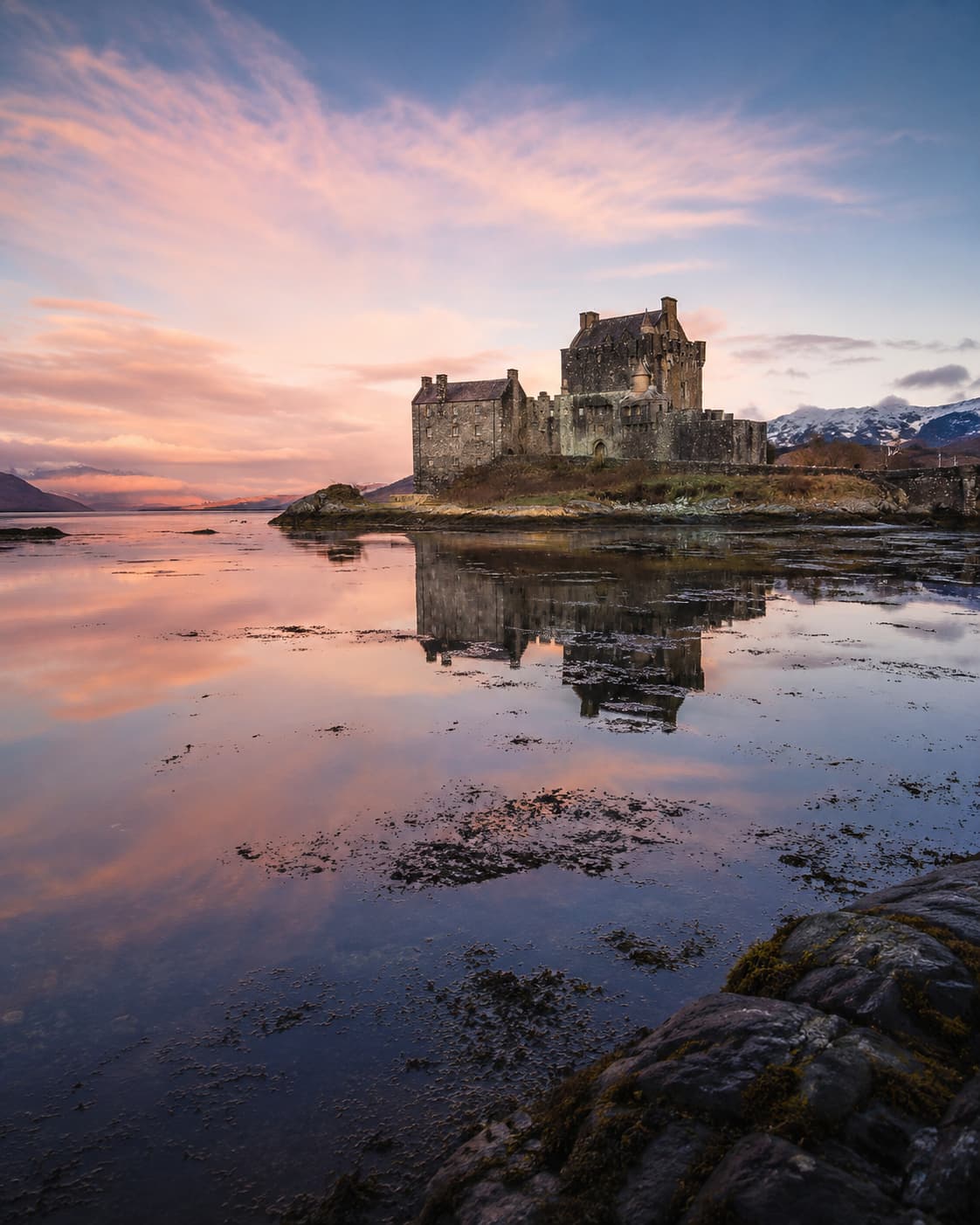 Eilean Donan Castle at sunset reflected in the loch — best time to visit Scottish castles