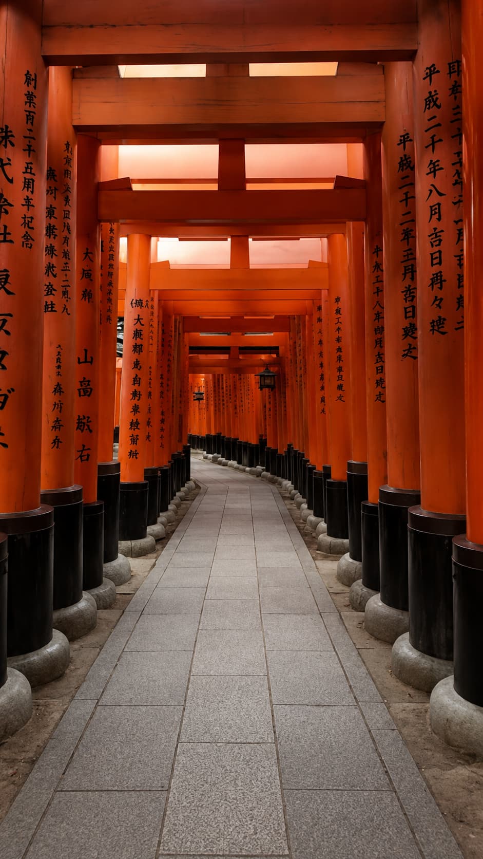 Fushimi Inari torii gate corridor in Kyoto — thousands of vermilion gates lining the path up the hillside, empty and glowing in still light