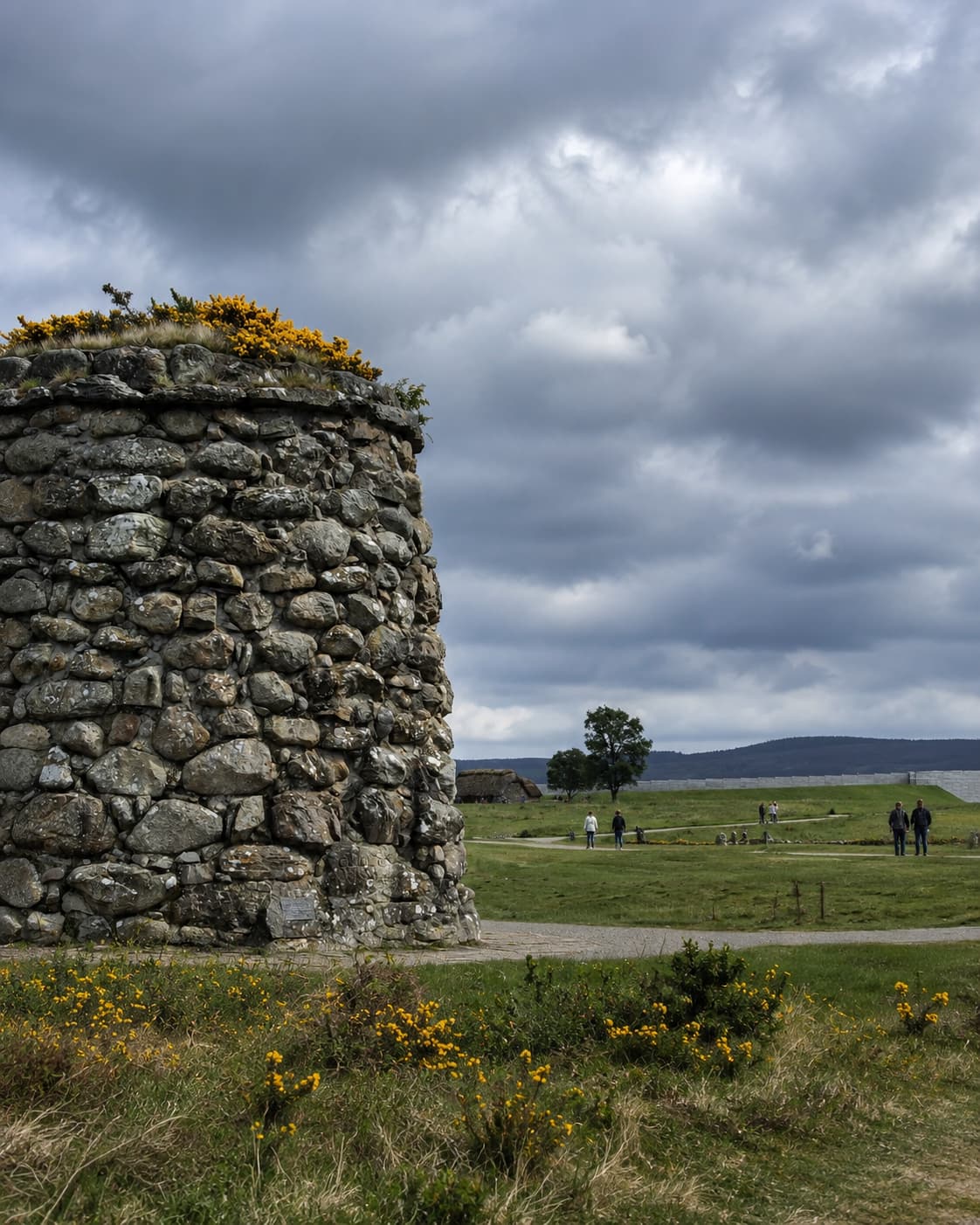 Culloden Battlefield memorial cairn with visitors walking the open moorland — among the most significant Outlander filming locations in Scotland