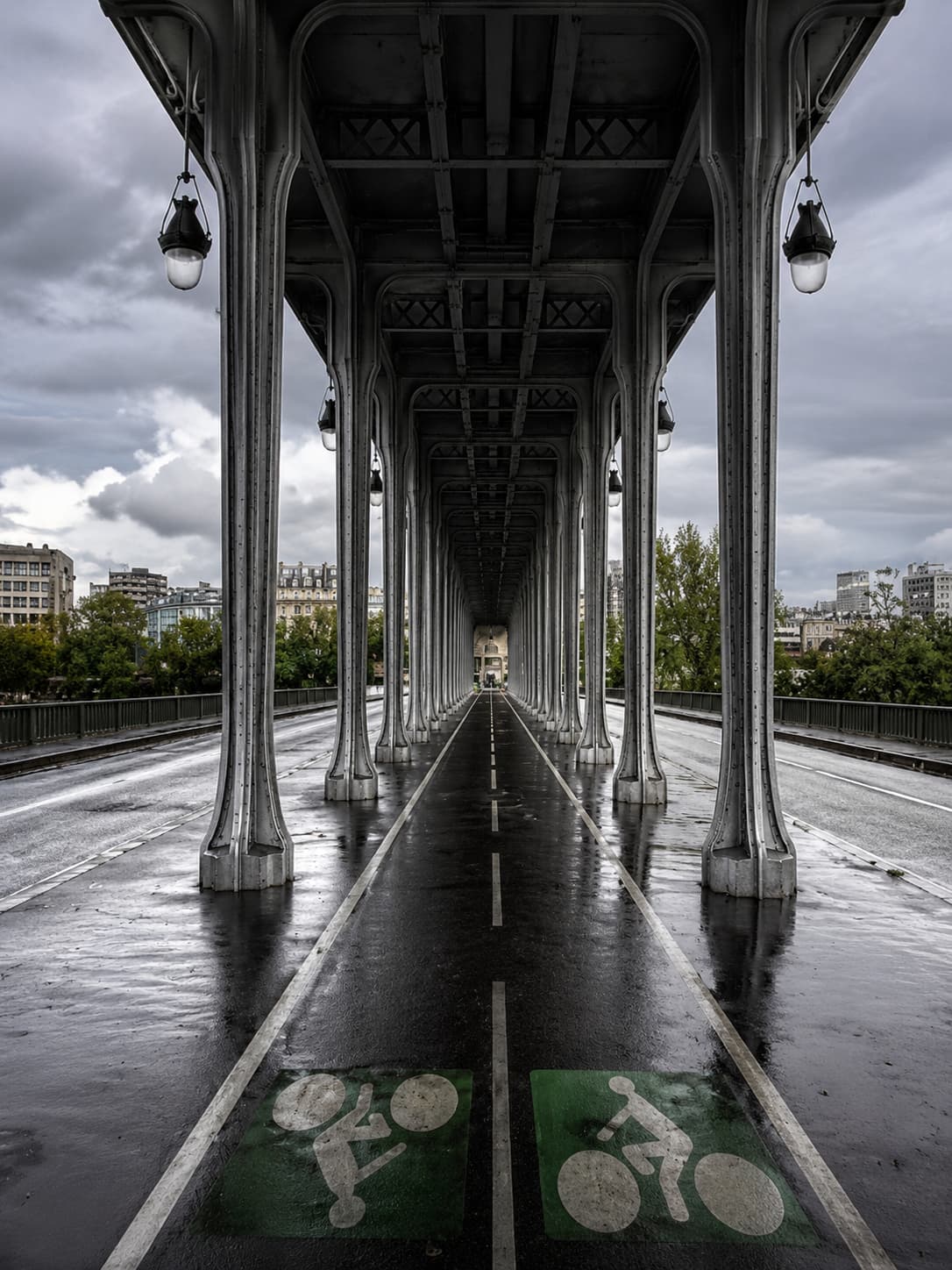 Bir-Hakeim bridge underpass in Paris, iron columns receding into the distance on a wet overcast day