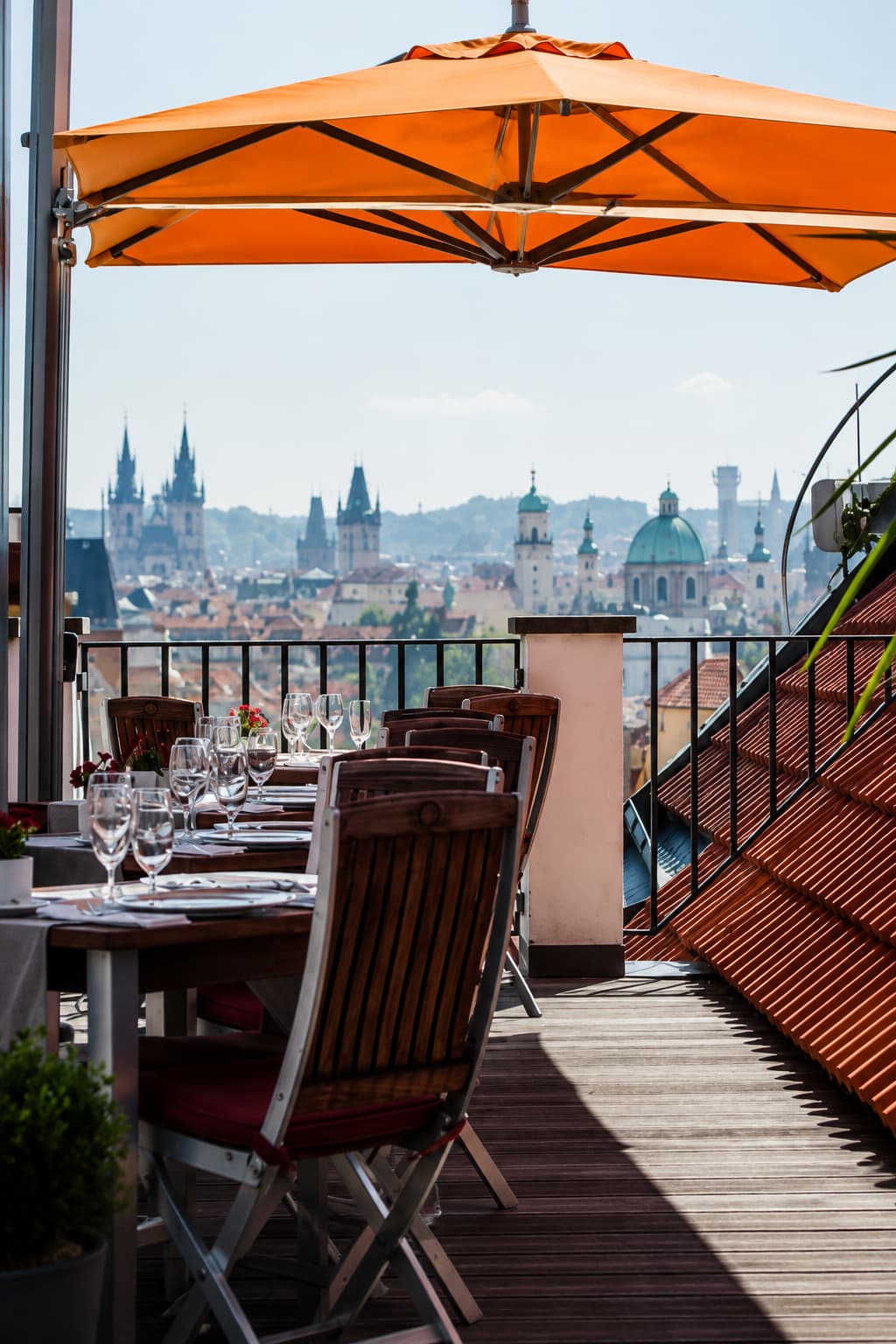 Rooftop terrace with orange parasol overlooking Old Town Prague spires — best cafes in Prague with a panoramic city view