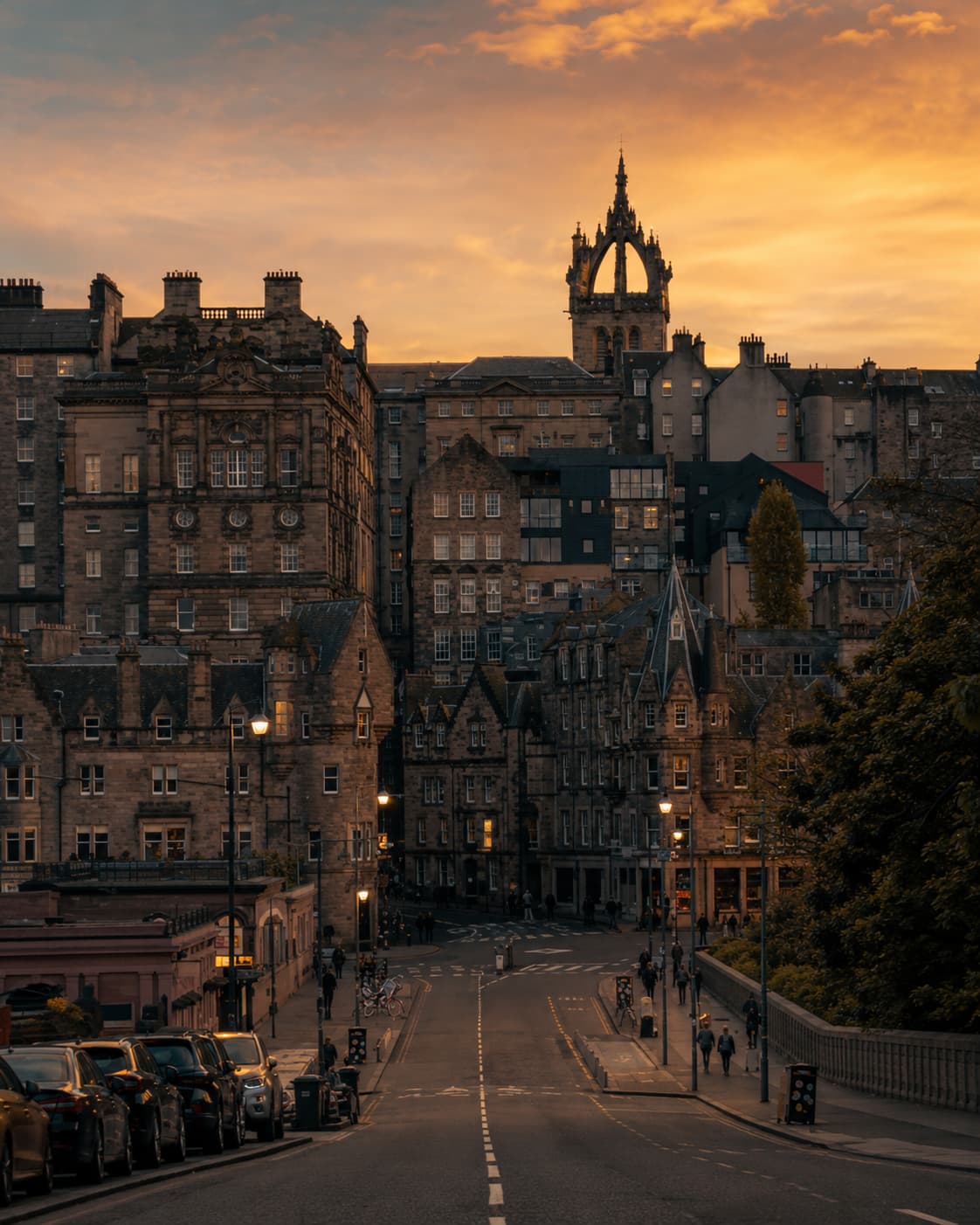 Edinburgh Old Town at sunset, stone tenements and St Giles Cathedral rising against a golden orange sky — Day 1 of this Scotland itinerary