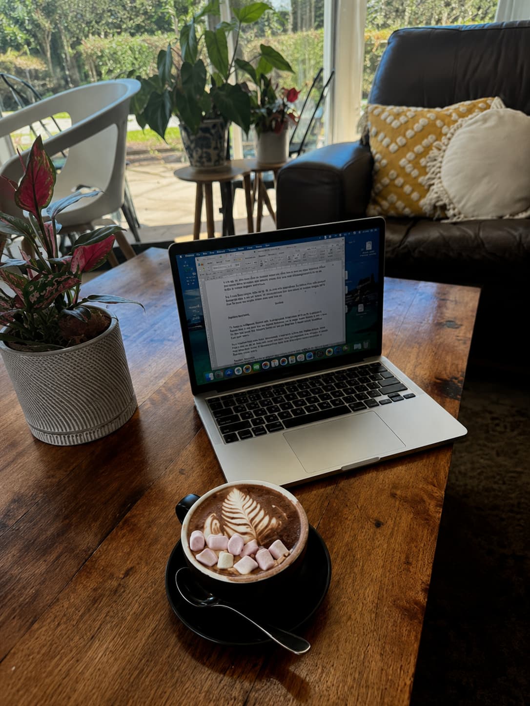 laptop and coffee on a wooden table — using AI to plan a trip