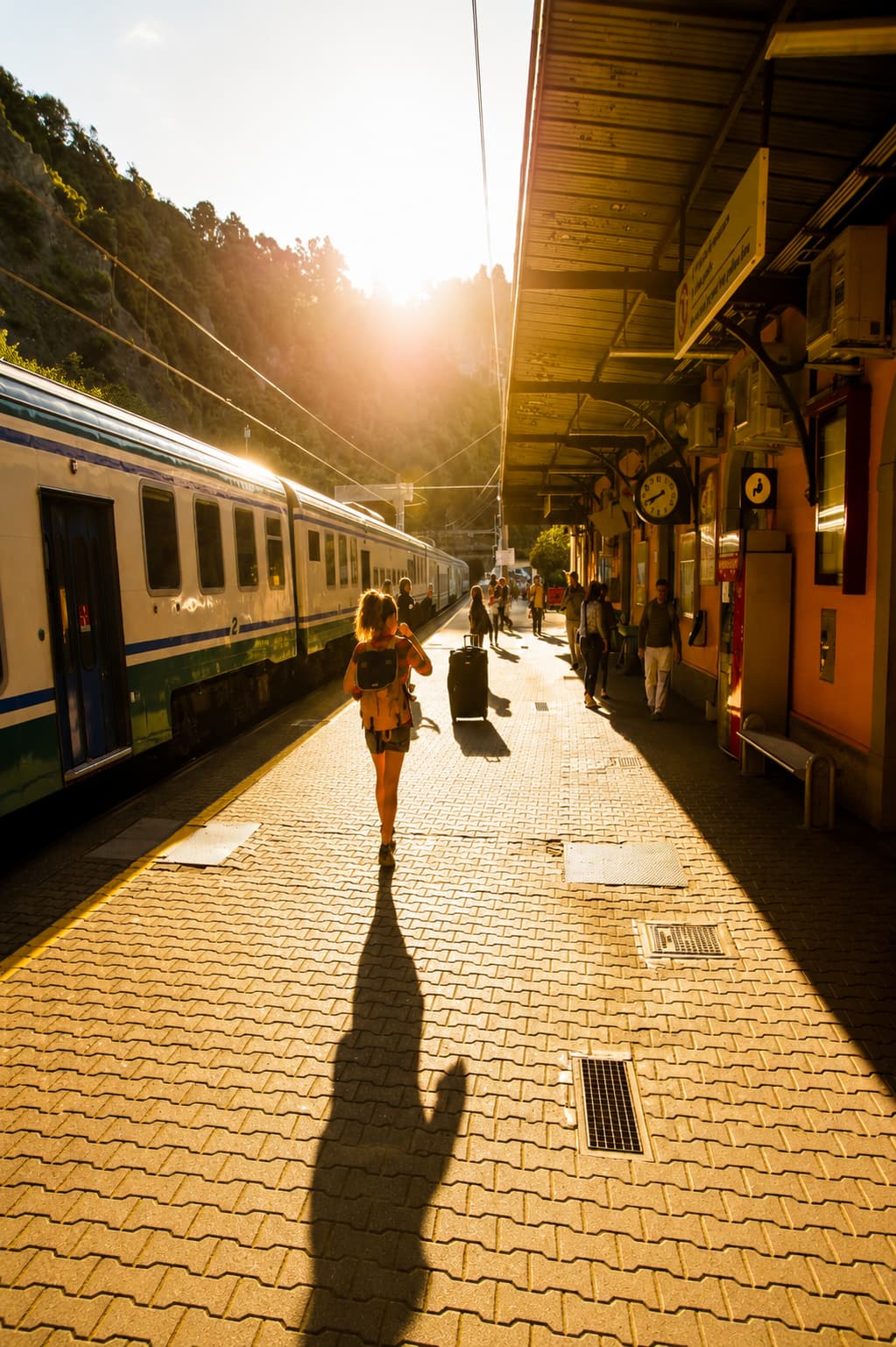 solo traveler walking on a train platform at golden hour — AI trip planning gets you here, but the journey is still yours
