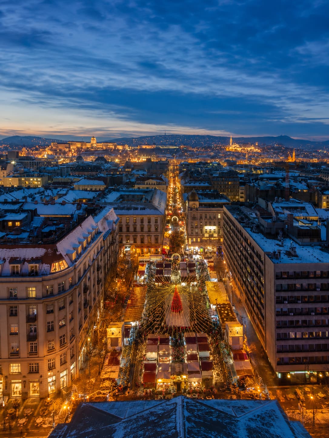 Budapest Vorosmarty Square Christmas market aerial view in snow with Buda Castle and Fishermans Bastion — European Christmas markets open past Christmas Day Hungary 2026