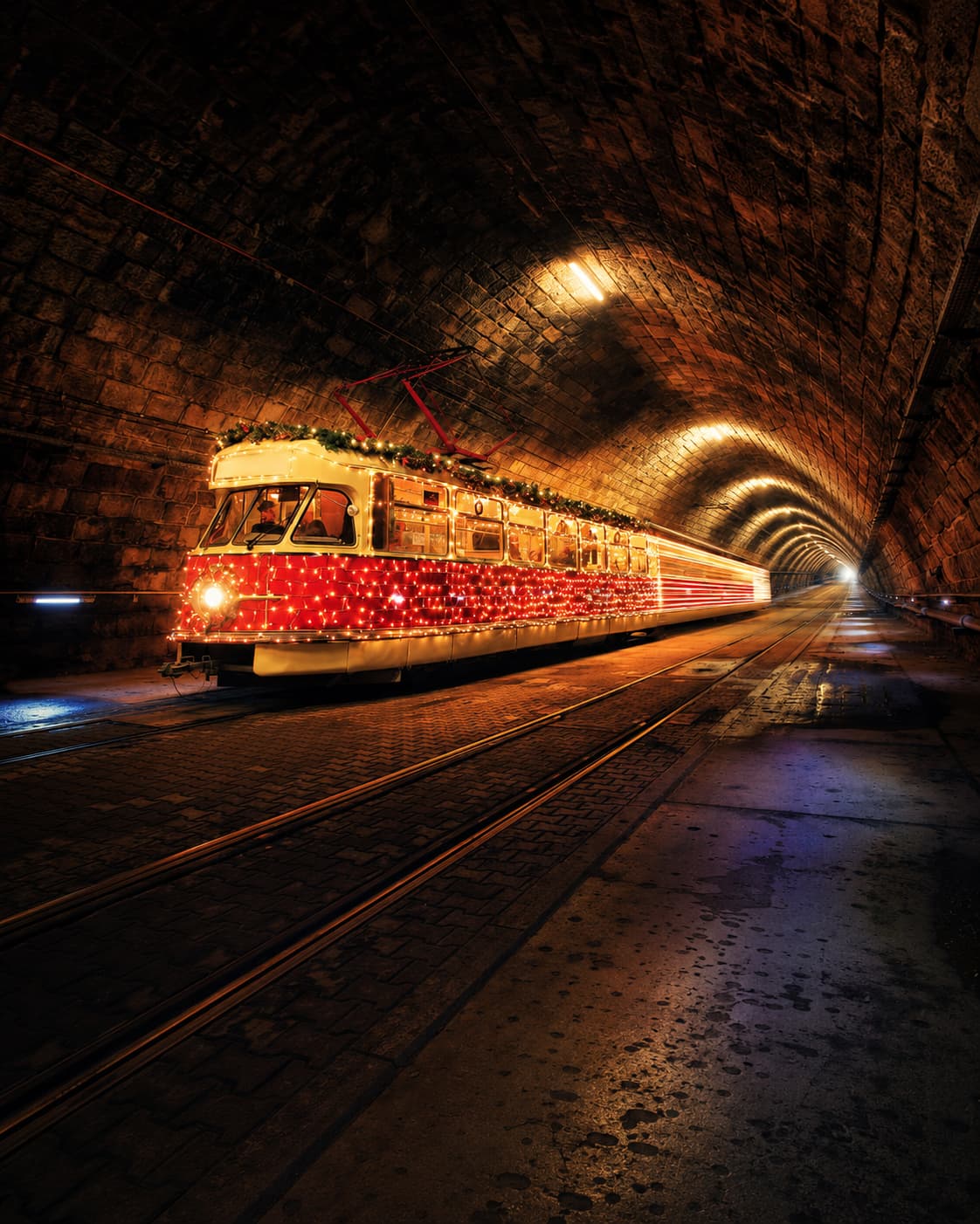 Bratislava Christmas tram decorated with red fairy lights in a stone tunnel — European Christmas market travel Slovakia winter 2026