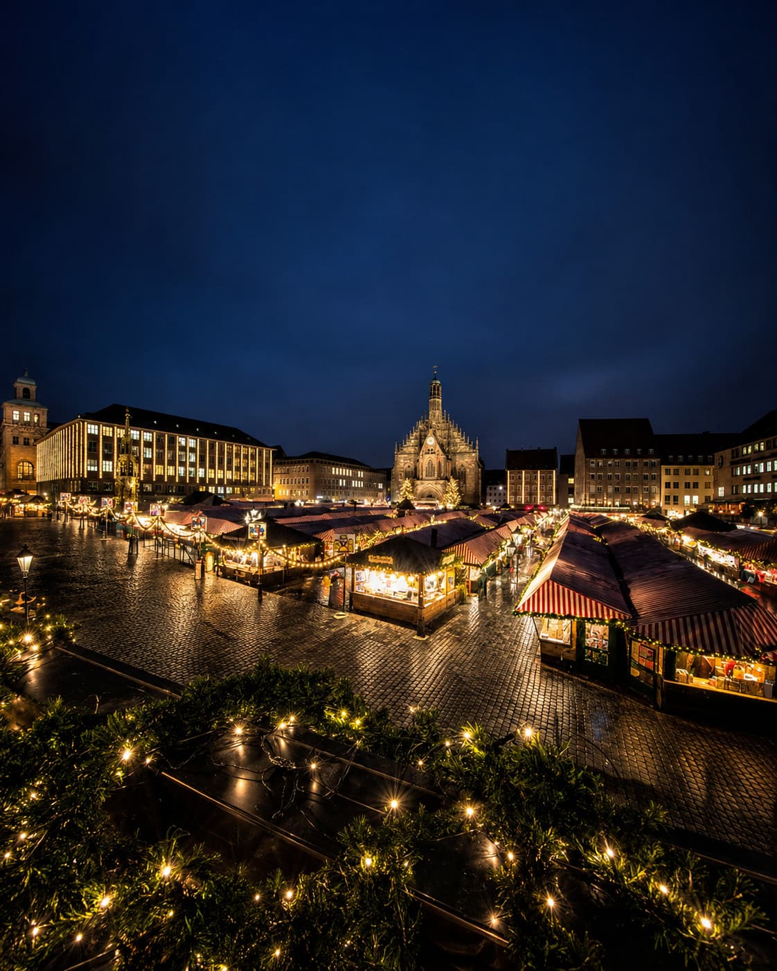 Nuremberg Christkindlesmarkt aerial view at night — European Christmas markets Germany with Frauenkirche church illuminated behind the stalls