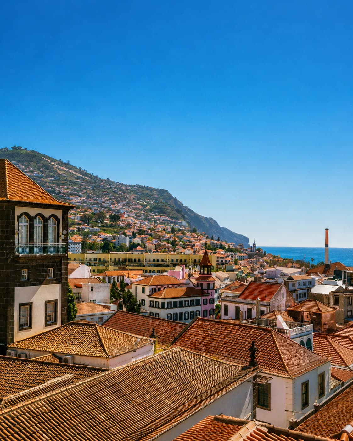 Funchal Madeira rooftop view with terracotta tiles and sea in background — December warm travel destination