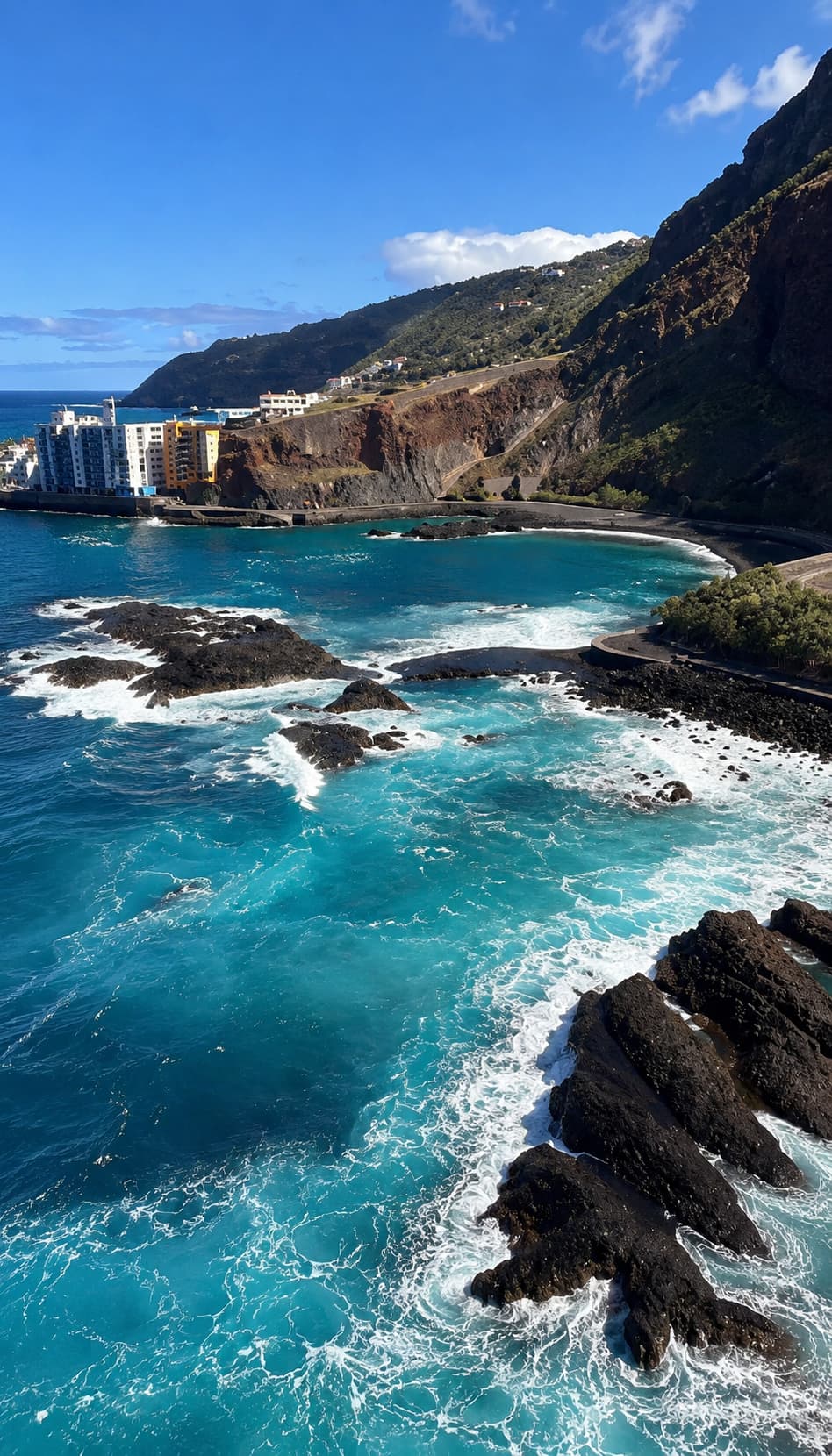Turquoise Atlantic waves breaking over volcanic rocks on the Tenerife coastline in November — the Canary Islands are the warmest places to go in Europe in November