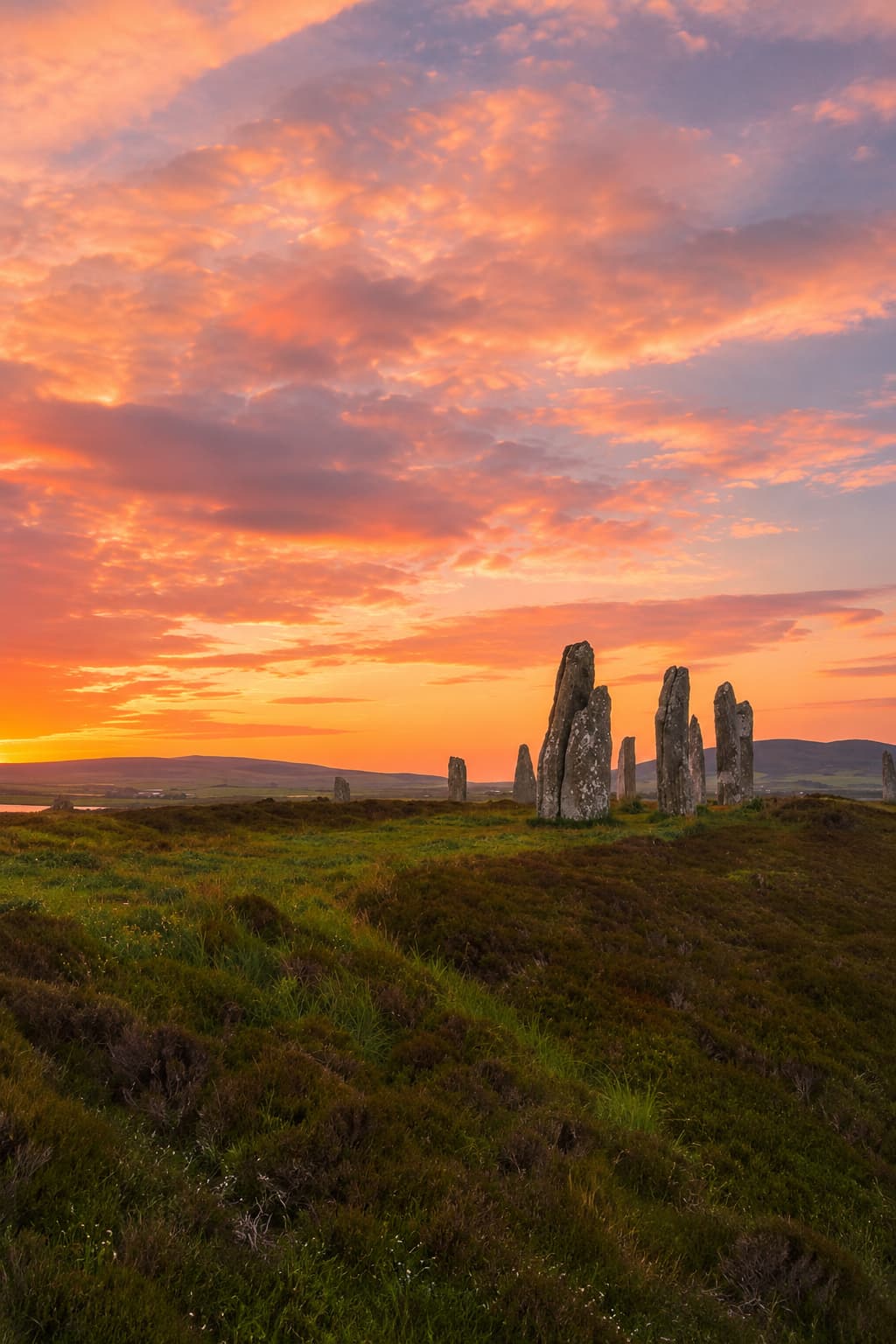 Ancient Celtic standing stone circle at vivid sunset in Scotland, the origin landscape of Halloween and Samhain tradition