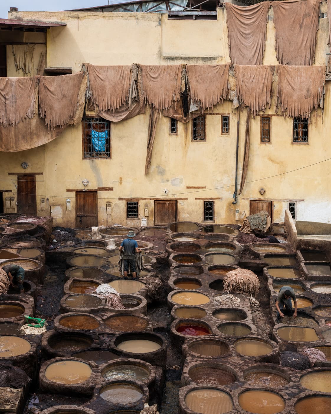 Chouara tannery in Fes with workers dyeing leather in circular stone vats — visit in spring or autumn for the best light