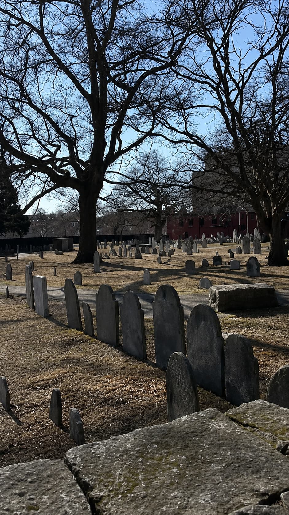 Charter Street Cemetery in Salem Massachusetts — 17th-century colonial headstones, bare trees, clear winter sky