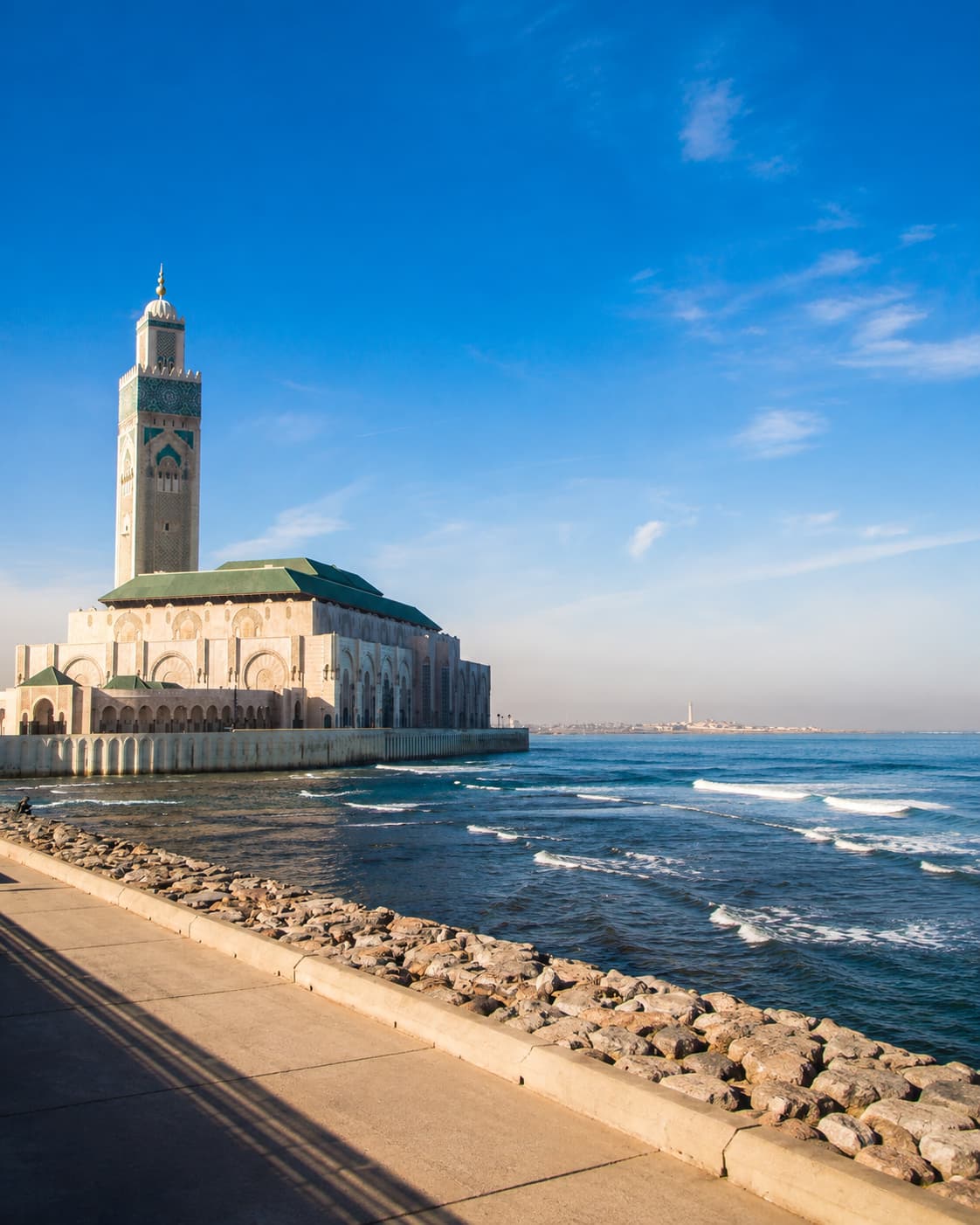 Hassan II Mosque in Casablanca seen from the oceanfront promenade in clear winter light — Morocco is one of the warmest and most affordable Thanksgiving travel abroad destinations in late November