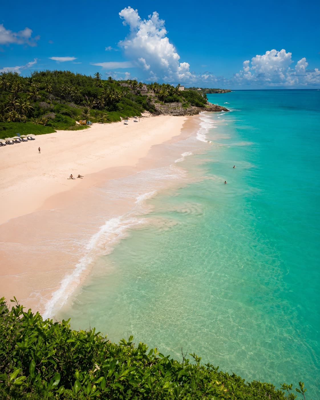 Elevated view of a pink sand Barbados beach with turquoise water and very few people — an ideal Thanksgiving travel abroad destination for East Coast flyers