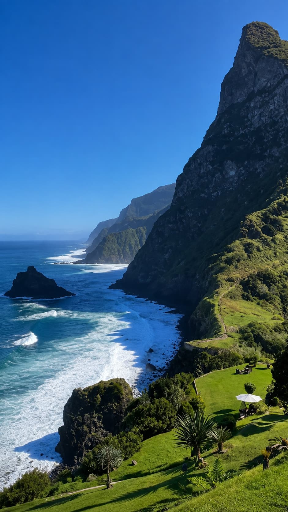 Dramatic volcanic cliffs of Madeira's north coast with green hillsides and Atlantic waves below — Madeira stays warm in November making it a strong Thanksgiving travel abroad pick