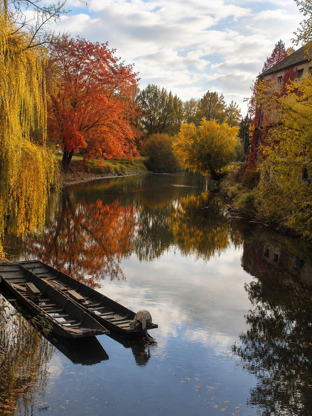 Old wooden boats on a quiet river near Sélestat in Alsace in autumn