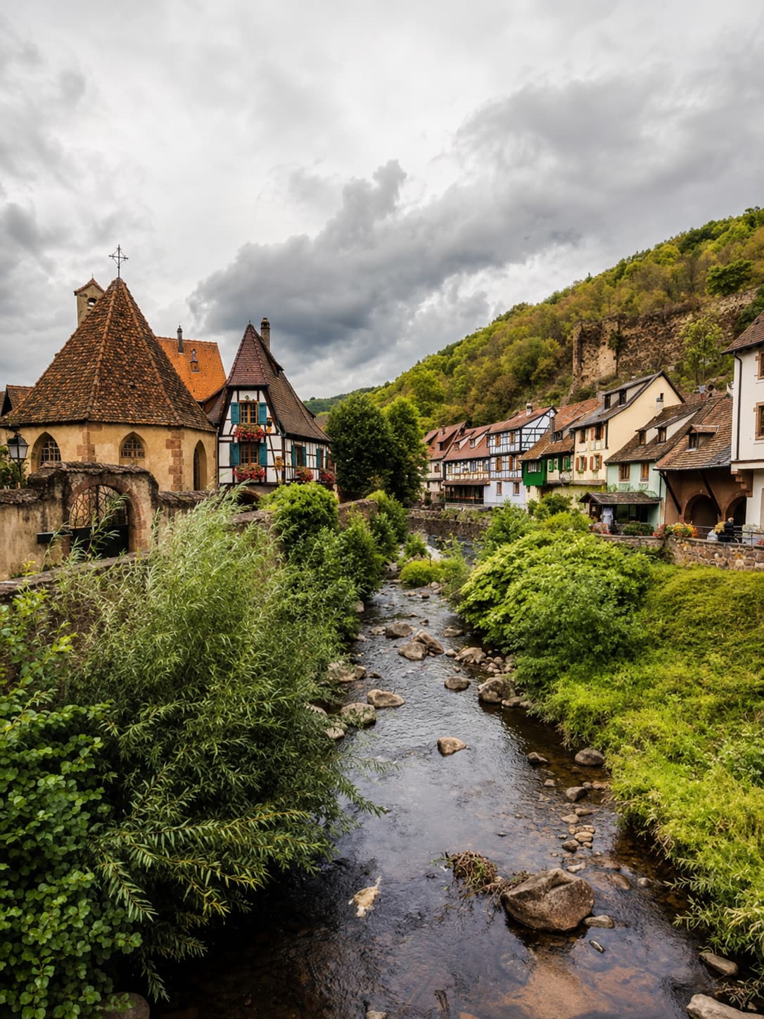 River running through a half-timbered Alsace village in autumn