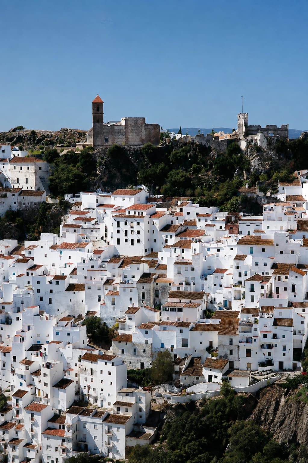 Casares white village stacked on a hillside with castle ruins above — pueblos blancos in Andalusia in autumn