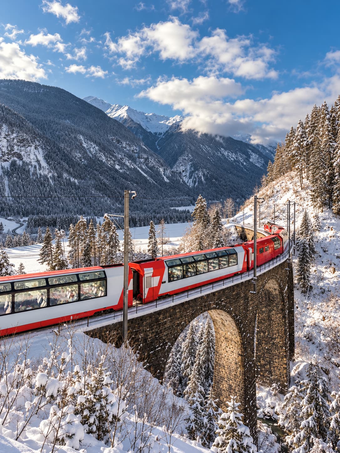 The Glacier Express red panoramic train crossing a stone viaduct through snow-covered Alpine forest in winter — one of the best things to do in Switzerland in winter without skiing