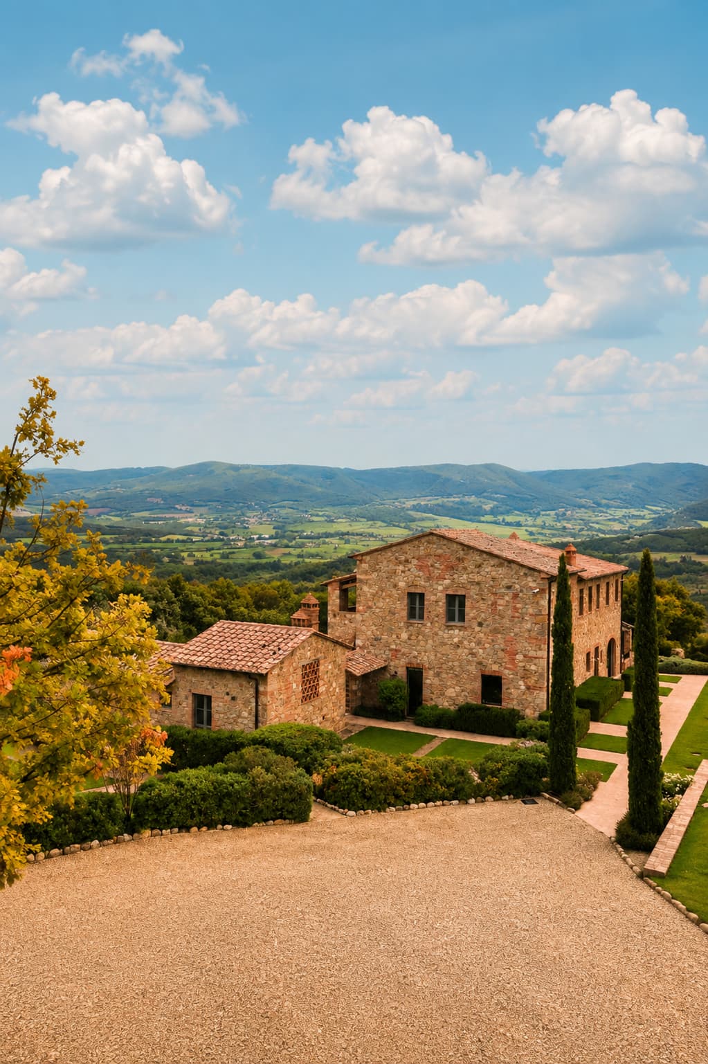 A stone Tuscan farmhouse surrounded by cypress trees and rolling autumn countryside